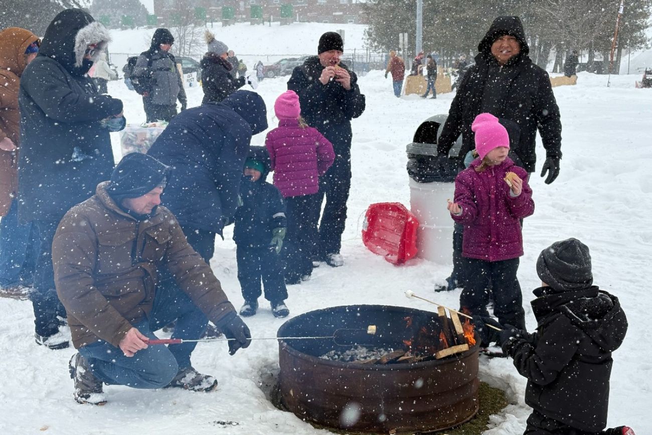 People standing around a fit pit in Alpena, Michigan.