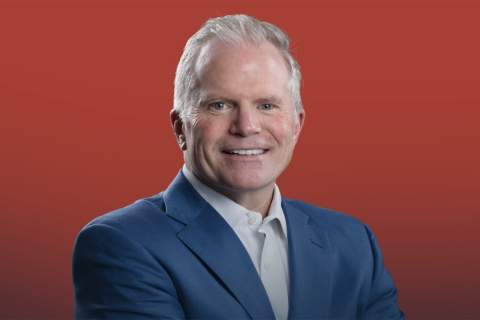 Former Michigan Attorney General Mike Cox headshot. There's a red background.